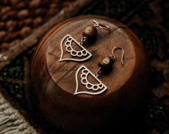 journey. a pair of bohemian earrings with golden henna-eque charms and carved wooden beads.