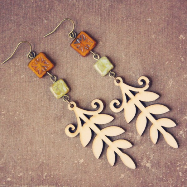 uma.  a pair of beaded cream wooden leaf earrings.