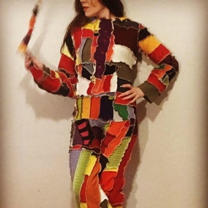 May include: A colorful patchwork jumpsuit with long sleeves and a button-up front. The jumpsuit is made of different fabrics and colors, including red, orange, yellow, green, blue, purple, and black.