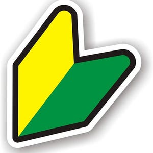 May include: A white sticker with a yellow and green design, outlined in black. The shape is a stylized V-shape, with the yellow section on the left and the green on the right. The sticker has a white border.
