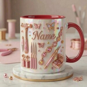 Puede incluir: Una taza blanca nacarada con interior y asa rojos, decorada con adornos rosas y dorados. La taza presenta herramientas, mariposas y el nombre "Name". Se apoya sobre un posavasos de mármol.