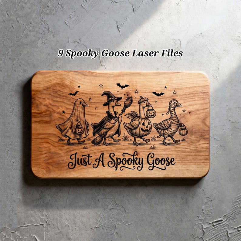 May include: A rectangular wooden board featuring a laser-engraved design of four geese in Halloween costumes, including a ghost, a witch, a pumpkin, and a mummy. The text 9 Spooky Goose Laser Files and Just A Spooky Goose is engraved.