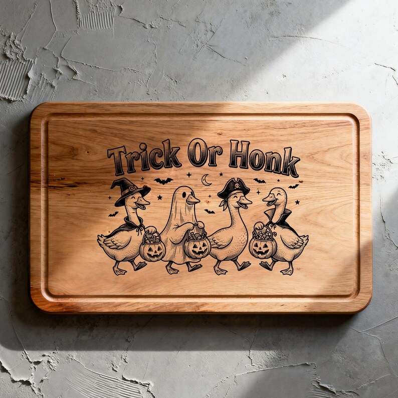 May include: A rectangular wooden cutting board featuring a laser-engraved illustration of four ducks in Halloween costumes, including a witch, a ghost, and a pirate, holding jack-o'-lantern buckets, with the text Trick Or Honk above them.