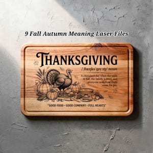 May include: A rectangular wooden cutting board featuring a laser-engraved design of a turkey, pumpkins, and wheat. The text reads Thanksgiving, a phonetic pronunciation, a definition, and the phrase Good Food, Good Company, Full Hearts.