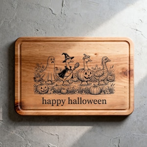 May include: A rectangular wooden cutting board featuring a laser-engraved illustration of four geese in Halloween costumes, including a ghost, a witch, a pumpkin, and a mummy, surrounded by pumpkins and the text "happy halloween" at the bottom.