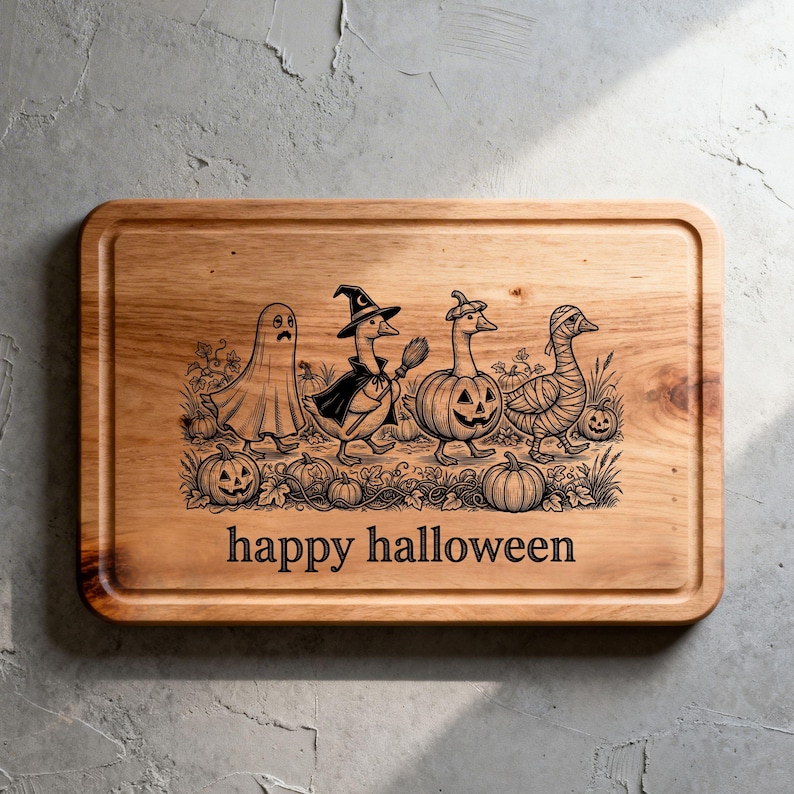 May include: A rectangular wooden cutting board featuring a laser-engraved illustration of four geese in Halloween costumes, including a ghost, a witch, a pumpkin, and a mummy, surrounded by pumpkins and the text "happy halloween" at the bottom.