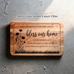 Pode incluir: Uma placa retangular de madeira com cantos arredondados, com texto e desenhos florais cortados a laser. A placa diz "Bless Our Home" com frases adicionais. O design inclui uma borda, flores e grama.