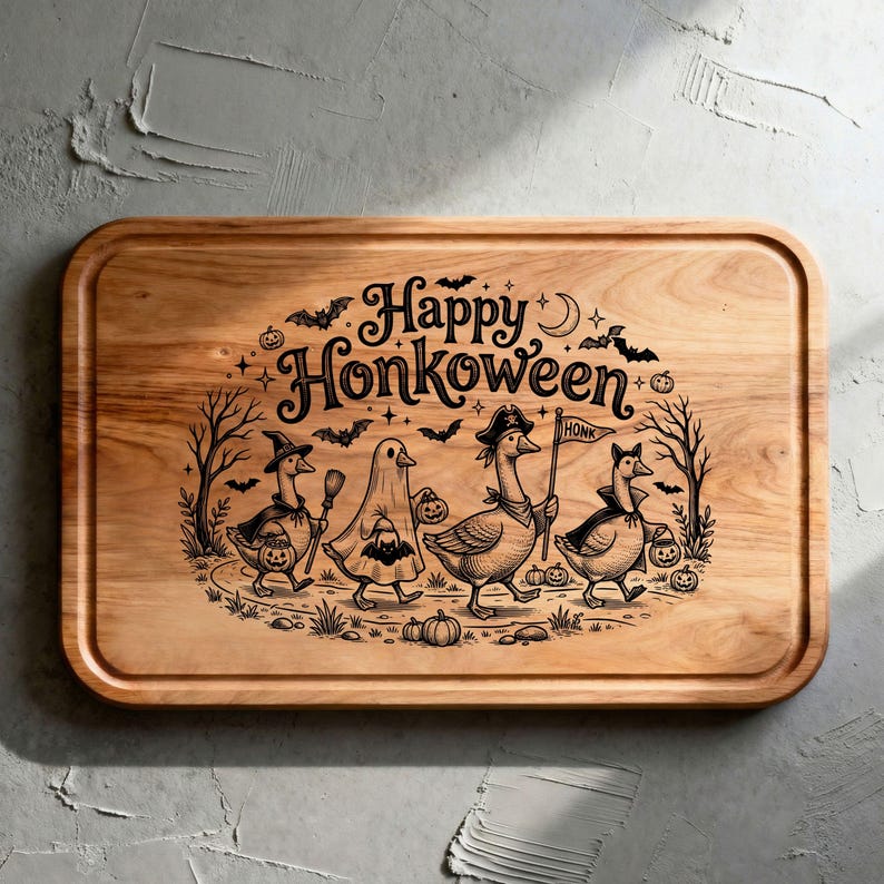 May include: A rectangular wooden cutting board featuring a laser-engraved illustration of four geese in Halloween costumes. The text reads Happy Honkoween, accompanied by bats, trees, and pumpkins. The board has rounded corners and a grooved edge.