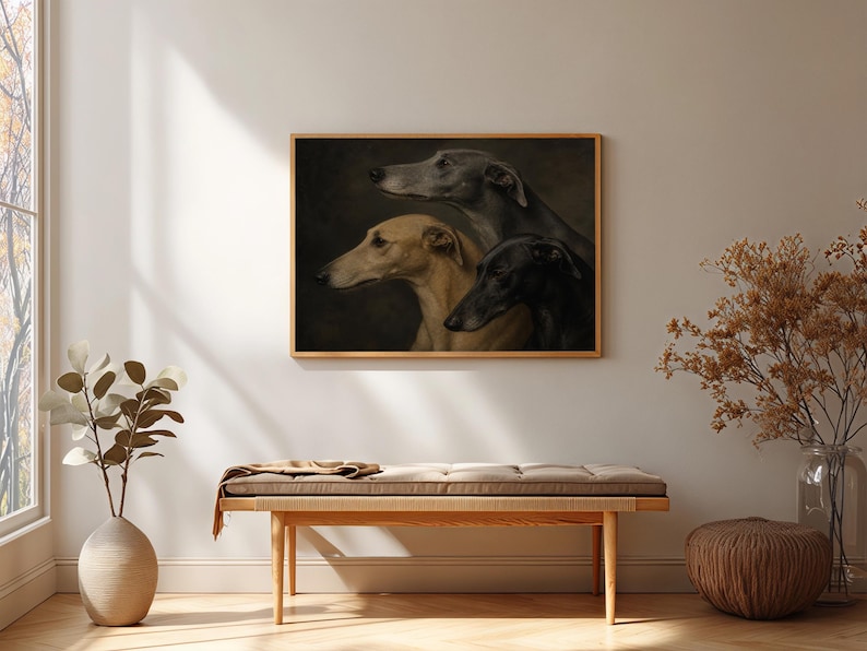 May include: A framed artwork featuring a portrait of three greyhounds. The dogs are depicted in profile, with varying shades of grey, tan, and black. The artwork is displayed above a wooden bench with a cushion.