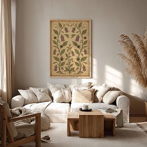May include: A rectangular wall art print featuring a symmetrical botanical illustration of purple bell-shaped flowers and green leaves on a textured beige background, enclosed in a simple light-colored wooden frame hanging on a plain wall.