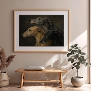 May include: Framed art print featuring three greyhounds in profile. The dogs are depicted in shades of grey, tan, and black against a dark background. The artwork is displayed in a light wood frame, adding a touch of elegance to the room.