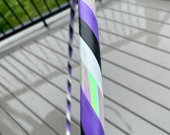 Könnte beinhalten: Ein lila, schwarz und weiß gestreifter Reifen mit schillernden Akzenten. Der Reifen ist aus Kunststoff und hat einen Durchmesser von etwa 91 cm.