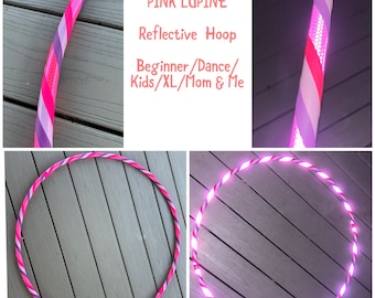 Könnte beinhalten: Ein reflektierender Reifen in Pink und Lila mit einem weißen Streifen. Der Reifen ist mit pinken LED-Lichtern beleuchtet. Der Text "PINK LUPINE Reflective Hoop Beginner/Dance/Kids/XL/Mom & Me" ist auf weißem Hintergrund geschrieben.