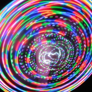 Puede incluir: Un aro LED de colores con múltiples capas de luces que crean un patrón de remolino de rojo, verde, azul y morado.