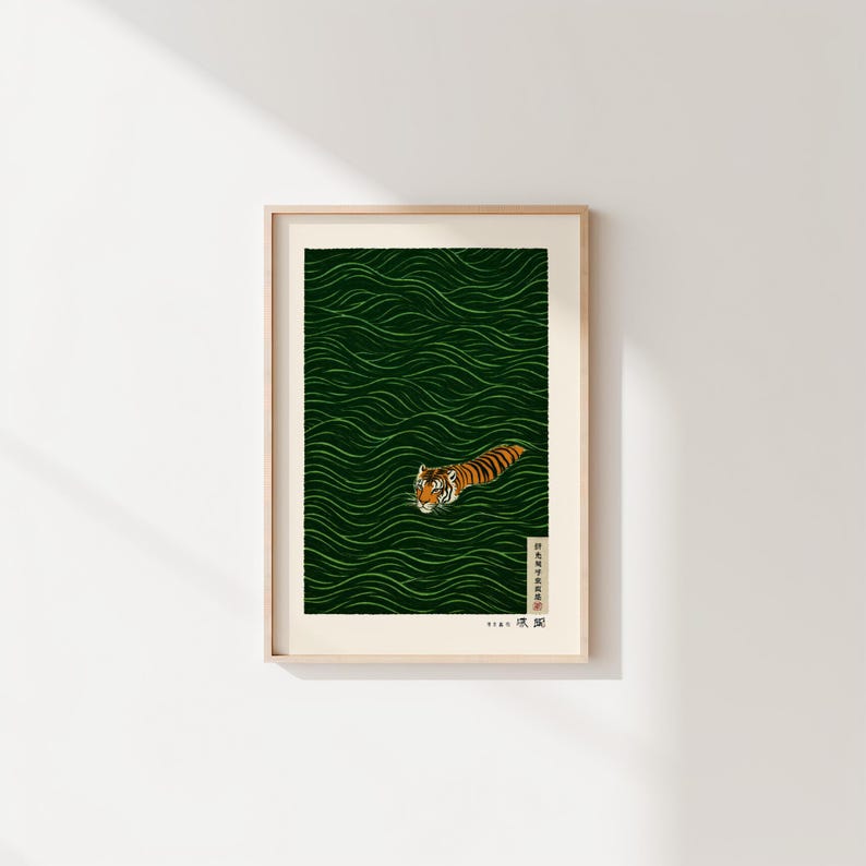 May include: Framed art print featuring a tiger swimming in green water. The tiger is orange and black, with its head above the water. The water has a wavy pattern. Japanese text is at the bottom right.