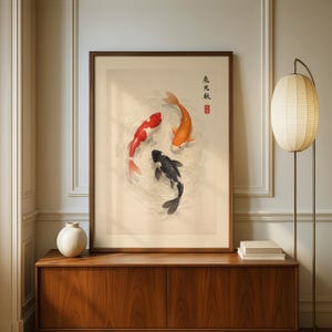 May include: A framed art print featuring three koi fish in a circular pattern. The fish are red, orange, and black, set against a neutral background. The artwork has Japanese text and a red seal.