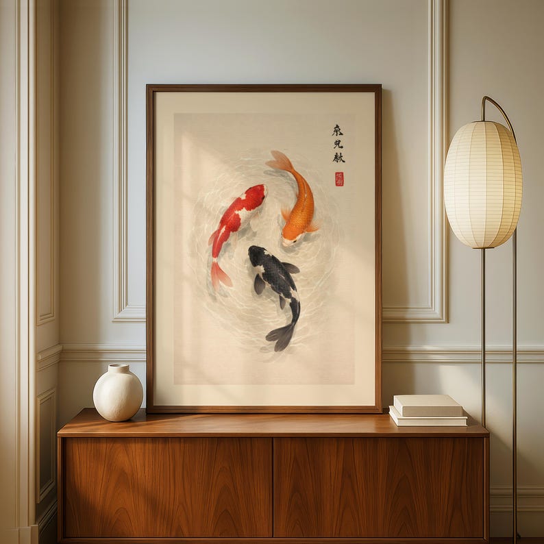 May include: A framed art print featuring three koi fish in a circular pattern. The fish are red, orange, and black, set against a neutral background. The artwork has Japanese text and a red seal.