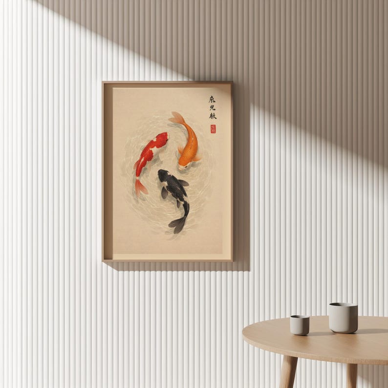 May include: Framed artwork featuring three koi fish in a circular pattern. The fish are red, orange, and black, set against a beige background. The artwork has Japanese text and a red seal in the upper right corner. The frame is a light brown color.