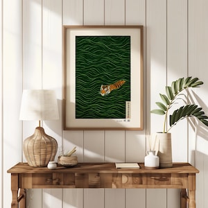 May include: Framed art print featuring a tiger swimming in green water with wave patterns. The tiger has orange and black stripes. The artwork is in a wooden frame and includes Japanese text.