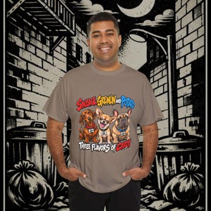 Könnte beinhalten: Ein taupefarbenes Kurzarm-T-Shirt mit einer Grafik von drei Hunden und dem Text Sausage, Gremlin and Potato sowie Three Flavors of Crazy. Die Hunde sind ein Dackel, ein Chihuahua und eine Französische Bulldogge, die jeweils ein Halsband tragen.