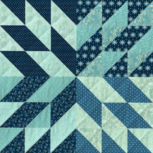 May include: A quilt made of blue and light blue fabric with a geometric pattern. The quilt is made of many different pieces of fabric, each with a different pattern. The quilt is a beautiful example of patchwork quilting.