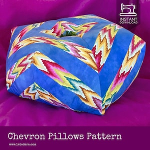 May include: A blue, yellow, pink, and green chevron patterned pillow. The pillow is shaped like a square with rounded corners. The pillow is sitting on a purple surface. Chevron Pillows Pattern www.latodera.com