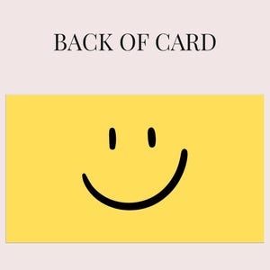 May include: A yellow card with a black smiley face and the text "BACK OF CARD" in black. The card has a light pink background.