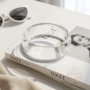 Peut inclure: Ensemble de trois mugs en céramique avec une finition mate et mouchetée. Les tasses sont de couleur crème, gris clair et gris foncé. Chaque mug a un design simple et minimaliste.