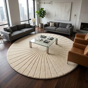May include: A large, circular, cream-colored area rug featuring a radial, sunburst-like pattern of raised, textured lines that extend from a smooth, solid circular center toward the outer edge, creating a distinct, tactile, and geometric design.