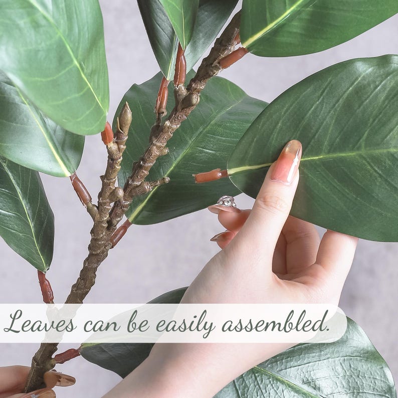 May include: An artificial plant branch featuring dark green, oval-shaped leaves attached to a textured brown stem with reddish-brown connectors. The text "Leaves can be easily assembled." is printed across the lower portion of the image.
