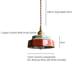 May include: A ceramic pendant light with a copper socket and knob switch. The lampshade is 14cm wide and red with a green and white patterned border. The adjustable wire is 200cm long, and the light fixture is 6cm tall. An LED bulb is included.