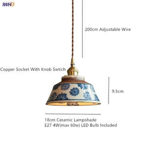 May include: A pendant light fixture with a ceramic lampshade featuring a blue floral pattern. The fixture includes a copper socket with a knob switch and an adjustable wire. The lampshade is 18cm in diameter and 9.5cm high.