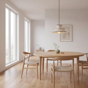 May include: A light-filled dining room featuring a round wooden table and four matching chairs. A cream-colored pendant light with a scalloped edge hangs above the table. The room has hardwood floors and large windows.