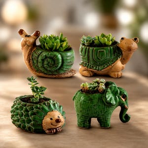 May include: Four ceramic animal-shaped planters featuring a snail, a turtle, a hedgehog, and an elephant. Each planter is painted in shades of green and tan, with a small green succulent plant growing from the hollow back of each animal figure.