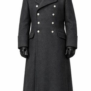 May include: A charcoal gray double-breasted overcoat with silver buttons, a notched collar, and a long, tailored silhouette. The coat features a black turtleneck and black gloves. The coat's length extends to the ankles.