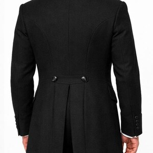 May include: A black formal coat with a tailored fit, featuring a notched lapel and a split tail design. The coat has two buttons at the waist and buttons on the sleeves. The back view shows the coat's elegant silhouette.