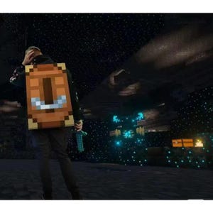 May include: A person wearing a pixelated backpack with a brown and tan design, and holding a blue sword. The background is a dark cave with glowing blue lights and a starry sky, reminiscent of a video game.