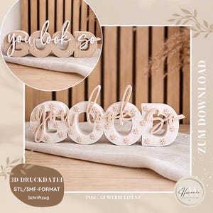 May include: Wooden decorative sign spelling "you look so". The letters are in a light beige colour, with a contrasting white or light beige colour for the text. The sign is placed on a neutral surface.