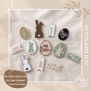 Puede incluir: Una colección de decoraciones de Pascua cortadas con láser en varias formas, incluyendo huevos, conejos y pancartas. Las decoraciones son en tonos neutros de marrón, blanco y verde, con textos como "Frohe Ostern" y "Hasige Grüße".