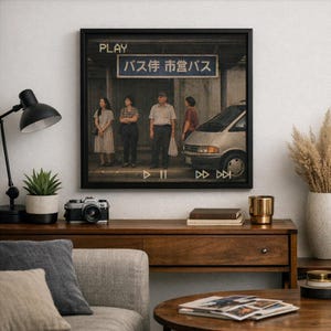 May include: A framed print depicting a Japanese bus stop scene with people waiting. The artwork has a vintage aesthetic, with a black frame and the word "PLAY" at the top. The print is displayed above a wooden console table.