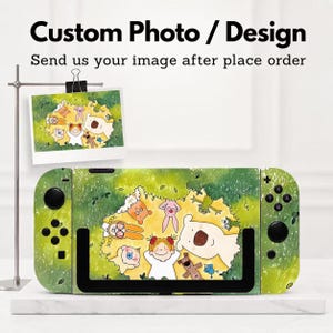 Op de afbeelding: Een skin voor een spelcomputer met een groene grasachtergrond en een cirkelvormige illustratie van een kind en diverse dieren. De tekst Custom Photo / Design en Send us your image after place order staat boven de console.