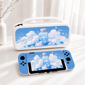 May include: A white carrying case and a handheld gaming console featuring a matching blue graphic print of a glass bottle filled with liquid, surrounded by fluffy white clouds, small stars, and a small white cat-like character at the base.