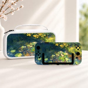 Könnte beinhalten: Eine weiße Tragetasche und eine tragbare Spielkonsole mit einem Aufdruck eines Teichs mit grünen Seerosen, dunkelblauem Wasser und gelbem Laub. Die Konsole verfügt über schwarze Tasten und Joysticks auf der linken und rechten Seite.