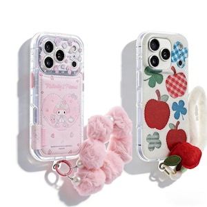 May include: Two phone cases and a pink scrunchie with pearls. One case is clear with a pink design and the text "Milady & Piano". The other case is white with red apple and flower designs. A white fluffy hair tie is also present.