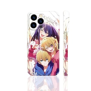 以下が含まれることがあります： 白の携帯電話ケース。紫、金髪、青の髪の毛を持つ3人の笑顔のキャラクターのカラフルなアニメスタイルのイラストが描かれています。ケースは光沢仕上げで、カメラの切り抜きがあります。