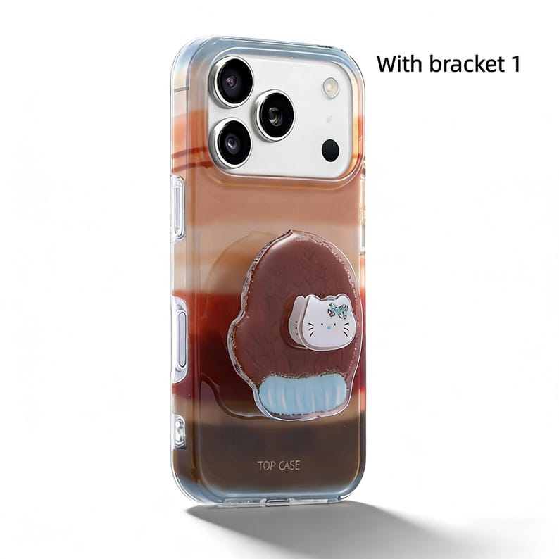 May include: Clear phone case with a gradient of brown, tan, and red hues. A cartoon cat design is on the back, with the text "TOP CASE" at the bottom. The case has a bracket and is designed for a smartphone.