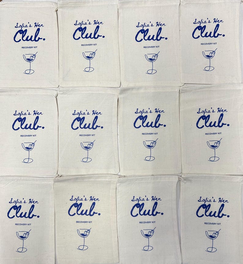 Puede incluir: Doce bolsas de algod&oacute;n de color hueso con cord&oacute;n, dispuestas en cuadr&iacute;cula. Cada bolsa tiene un estampado azul con el texto Sofia's Hen Club. RECOVERY KIT y un dibujo lineal de una copa de martini con una aceituna en un palillo.