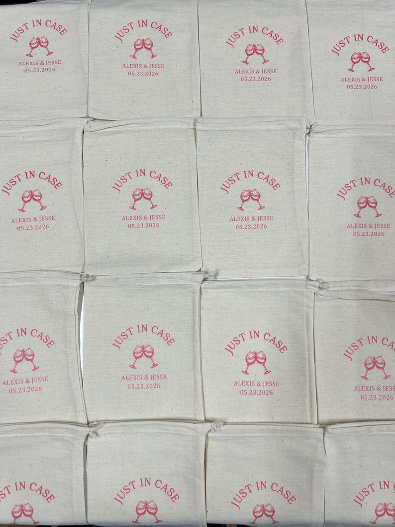 Puede incluir: Una colecci&oacute;n de bolsas de algod&oacute;n de color blanco roto con cord&oacute;n, dispuestas en cuadr&iacute;cula. Cada bolsa presenta un dise&ntilde;o impreso en rojo con dos copas de vino brindando, el texto "JUST IN CASE", los nombres "ALEXIS & JESSE" y la fecha "05.23.2026".