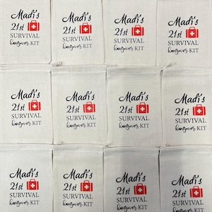 Puede incluir: Un conjunto de doce bolsas de algod&oacute;n de color hueso con cord&oacute;n, dispuestas en cuadr&iacute;cula. Cada bolsa presenta el texto negro Madi's 21st SURVIVAL hangover KIT y un icono de cruz m&eacute;dica roja sobre un gr&aacute;fico de bolsa rectangular roja.