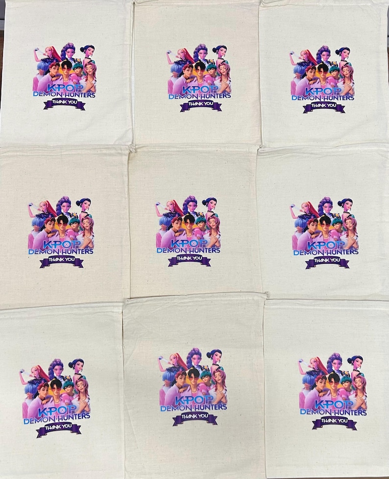 Puede incluir: Un conjunto de nueve bolsas de algod&oacute;n de color blanco roto con cord&oacute;n, cada una con un gr&aacute;fico impreso de un grupo de personajes estilo anime. Debajo de los personajes, el texto KPOP DEMON HUNTERS y THANK YOU aparece en una banda morada.